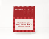 Red checkered calendar with motivational quote on a display easel