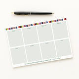 Weekly planner pad with colorful border and pen on a white background
