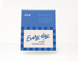 Blue checkerboard design calendar with motivational quote on a white background