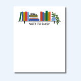 Notepad with colorful books illustration and 'Note to Shelf' text on a white background
