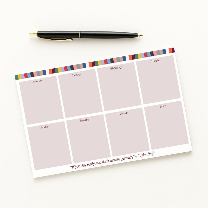 Tay Weekly planner pad with colorful border and pen on a white background